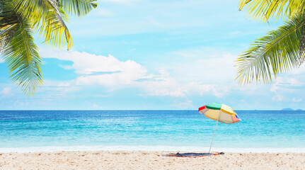 Colorful umbrella  on sand over blue sky and sea landscape.