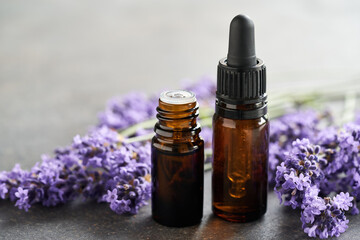 Brown essential oil bottles with fresh blooming lavender