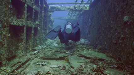 Scuba diver swim down corridor of ferry Salem Express shipwreck, Red sea, Safaga, Egypt