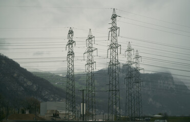 High voltage electric pole in the Alpine scenery. High voltage electric pole in mountains valley.