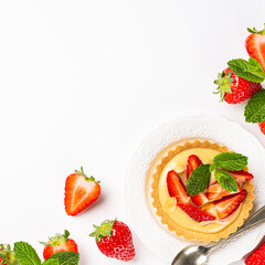 Flat lay with strawberry mini cake tartlet with vanilla custard and mint leaves over white background. Concept of homemade healthy sweet pastries. Copy space, top view, above
