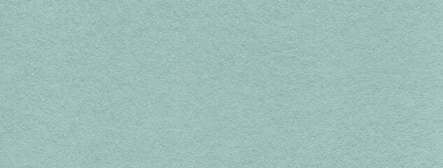 Texture of old light blue color paper background, macro. Structure of a vintage craft teal cardboard.