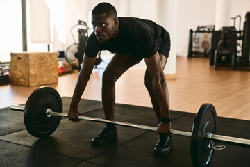 Fototapeta na wymiar Black athlete doing barbell deadlift during workout
