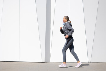 Woman in grey sportswear exercising and looking energetic