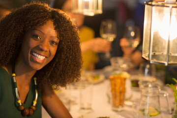 Portrait smiling woman dining with friends in restaurant