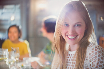 Portrait smiling woman dining with friends in restaurant