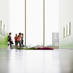 Women talking at window in exercise class gym studio