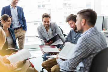 Business people reviewing and discussing paperwork meeting in office