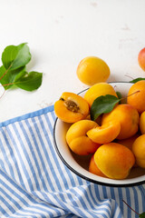 Ripe sweet apricots in enamel bowl close up