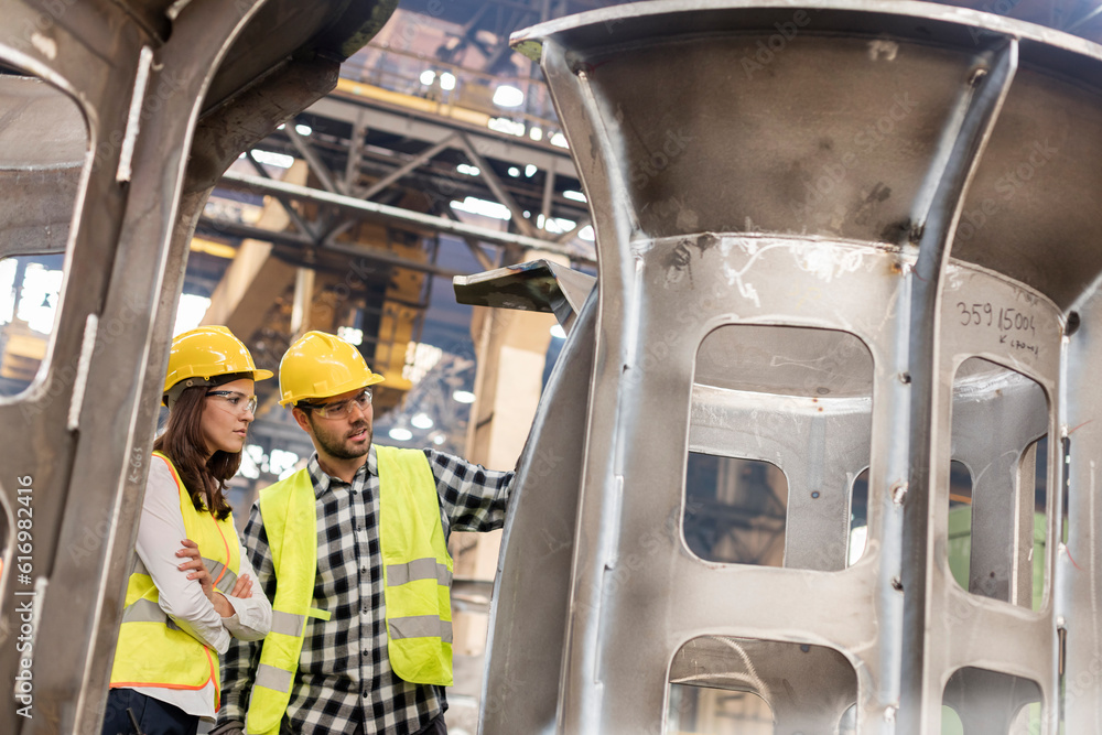 Wall mural Steel workers examining part in factory