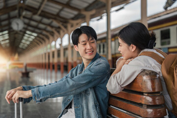 Asian couple travelers, backpack travelers, together at train station platform. tourism activity or railroad trip traveling concept