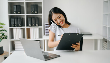 Happy asian business woman have the joy of talking on the smartphone, tablet and laptopon the office