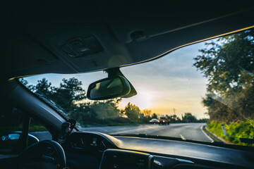 View from the car while driving on an asphalt road at sunset