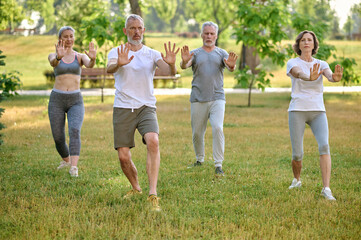 A group of people practicing yoga in a park