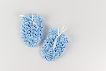 hand knitting pair of cute newborn knit baby mittens on white background 