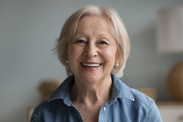 Head shot portrait happy beautiful retired woman. Mature female advertises professional services of...