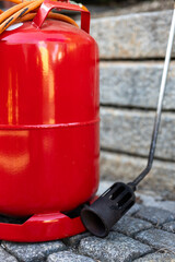 a red gas bottle with burner
