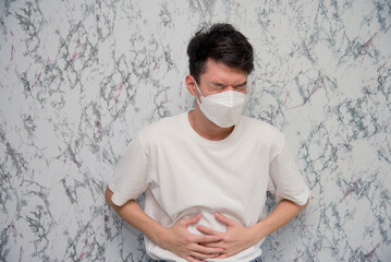 Man puts on a face mask tummyache isolated on White background,pandemic and social distancing concept.Covid-19