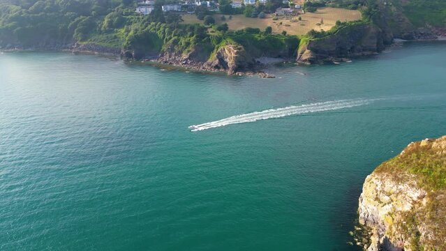 Speed boat passing Torquay coastline