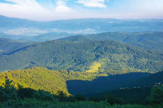 green rolling hills and grassy meadows. mountainous nature background at sunrise. sunny weather in summertime
