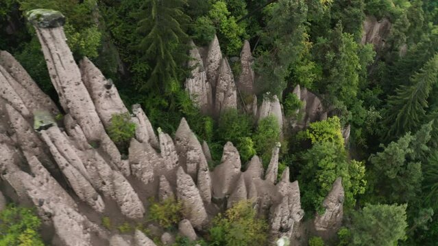 Aerial view circling over the Rittner Erdpyramiden pillars, in misty Tyrol, Italy