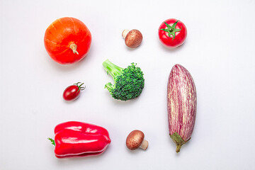 Creative arrangement of pumpkin, eggplant, bell pepper, sherry tomato, tomato, broccoli and mushrooms on a white background. Food concept. Healthy food.