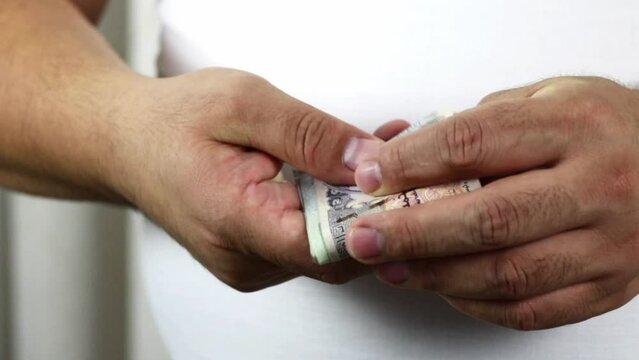 Hands counting dirham banknotes