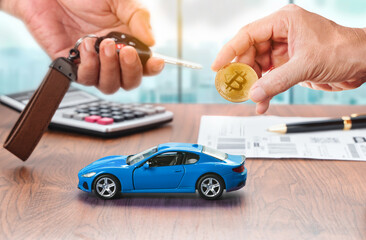 Buying a new blue car with cryptocurrency. Salesman giving a car key to buyer that pay with bitcoin in hand.