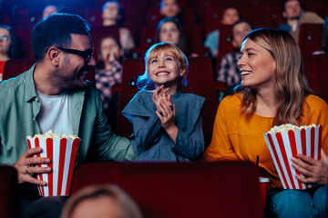 Joyful family watching movie in theater.