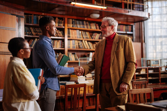 Professor congratulate students on success.