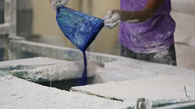 A view of workers pouring soap ingredients from bags into the feed hopper chamber