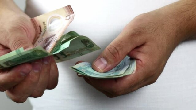 Hands counting dirham banknotes