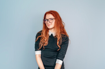 Cute girl with long red hair in glasses. Student. Education, higher education, courses.