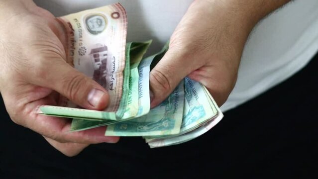 Hands counting dirham banknotes