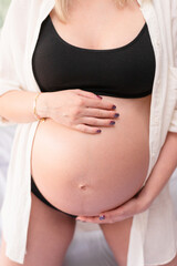 Closeup of a pregnant belly in studio lighting