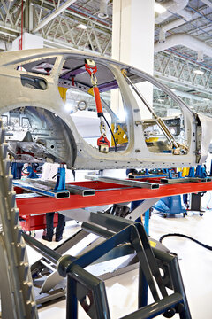 Metal car coachbuilder on lift in factory