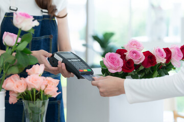 Cropped shot of female florist giving credit card to customer