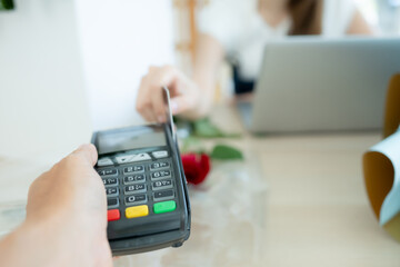 Close-up of a woman paying with credit card in floral shop