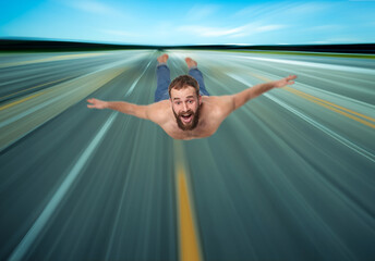 Happy fun bearded man taking off with arms outstretched like an airplane, blurred runway motion blur.