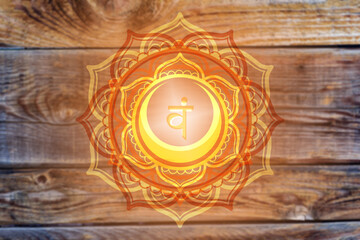 Svadhisthana chakra symbol on wooden  background. Artwork with mystical natural elements.