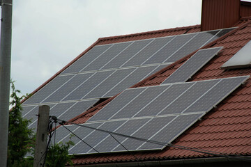Installing a Solar Cell on a Roof. Solar panels on roof. Historic farm house with modern solar panels on roof and wall. High quality photo