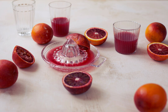 Blood oranges and squeezer on table