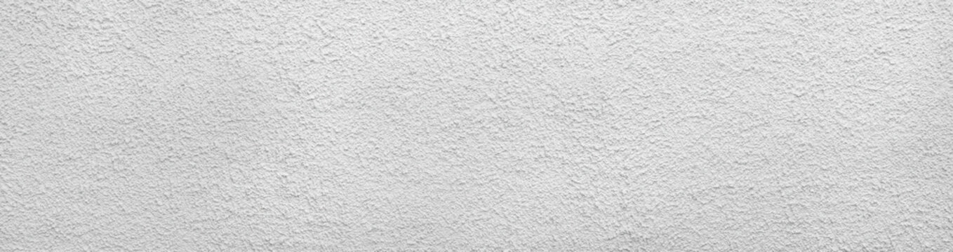 Hellgrau wei&szlig;e Rauputz Wand mit vielen kleinen schwarzen Punkten in der sehr groben Oberfl&auml;che - Panorama Nahaufnahme