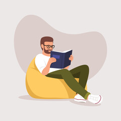 man sitting on a chair (ottoman) with a book