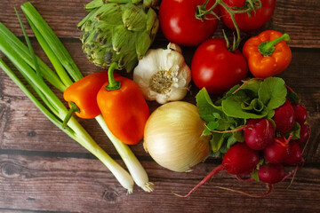 Fresh vegetables. Produce. Agriculture. Harvest. Tomatoes, artichoke, peppers, garlic, radish, onions. Top view. Healthy eating. Nutrition. Vegetarian. Vegan. Organic.