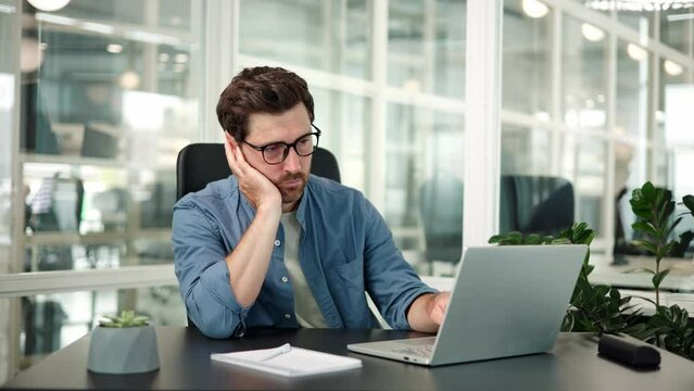 Bored man male service manager in glasses have displeased look. Sleepy yawning boredom specialist at workplace in office. Tired exhausted businessman entrepreneur feeling depressed, unhappy, burnout.
