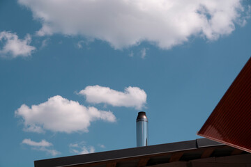 Chimney on the roof of the house against the blue sky