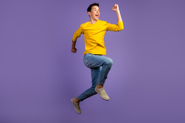 Fototapeta na wymiar Full-length portrait of crazy excited handsome man jumping up runner fast sale isolated on shine background