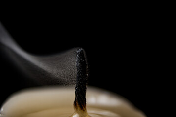 An extinguished candle close-up on a black background