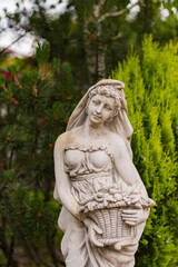 beautiful statue of a girl in a green garden